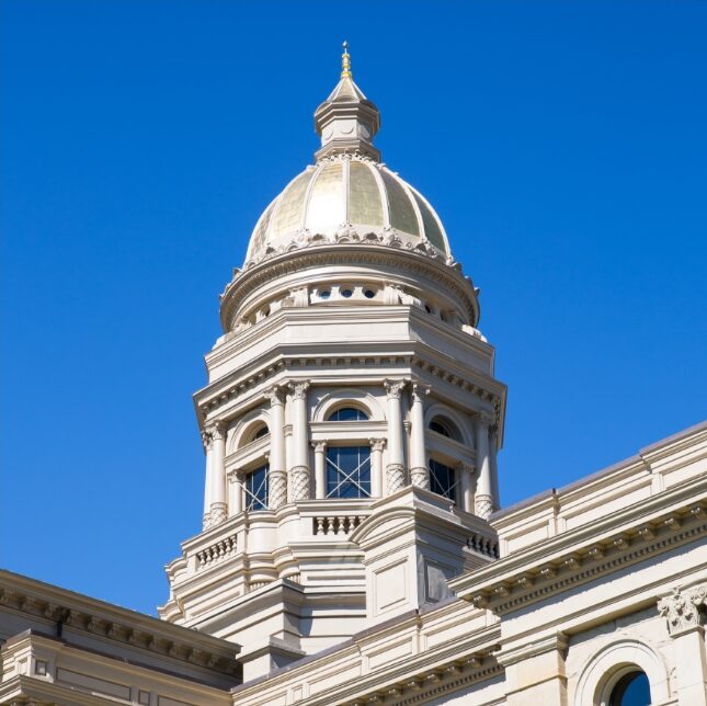 The Wyoming State Capitol at day time with a clear blue sky