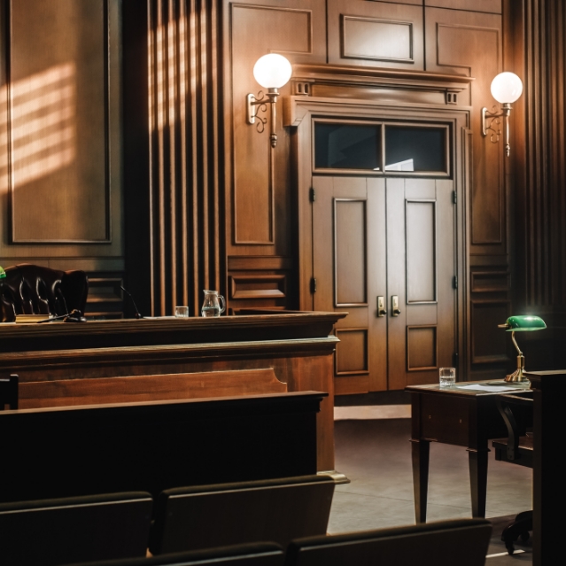 A courtroom in the morning is well lit with sun streaming in from the window