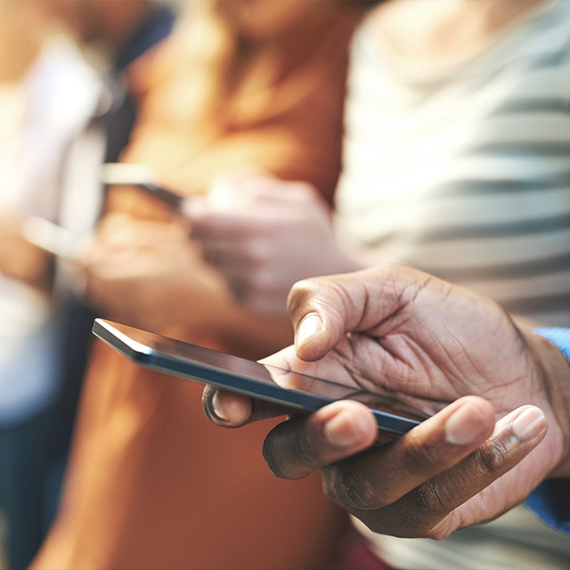 a man holding a phone with people in the background